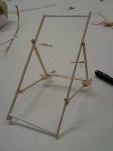 Folding deckchair frame made of coffee stirrers with wire hinges